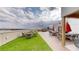 This rooftop deck features turf, lounge seating, tables, and an outdoor grill at 112 Rogers St # 409, Atlanta, GA 30317