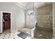 Bright bathroom showcasing a glass-enclosed shower and separate tub beneath a shuttered window at 2046 Chambord Way, Snellville, GA 30078