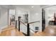 Hallway with hardwood floors, glass railing on the staircase, and views into other rooms at 2046 Chambord Way, Snellville, GA 30078