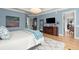 Large main bedroom showcasing hardwood floors, a cozy rug, and a light blue accent wall at 2046 Chambord Way, Snellville, GA 30078
