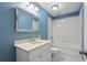 Stylish bathroom with blue walls, white vanity, and a shower-tub combination with white tile at 6 Walnut Hill Nw Pl, Atlanta, GA 30318