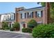 Charming brick townhome featuring a red front door, black shutters, and manicured landscaping at 6 Walnut Hill Nw Pl, Atlanta, GA 30318