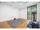Bright workout room with hardwood floors, exposed ceiling beams, and large sliding door at 2575 Peachtree Ne Rd # 8D, Atlanta, GA 30305