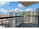 A high rise balcony has views of the city skyline and blue skies with black metal safety railing at 3481 Lakeside Ne Dr # 2303, Atlanta, GA 30326