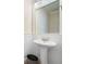 Bathroom with pedestal sink, mirror, and white wainscoting for a classic and clean design at 1564 Spring Se St, Smyrna, GA 30080