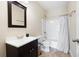 Bathroom with dark vanity, tile floors, and a shower/tub combination with a stylish curtain at 1564 Spring Se St, Smyrna, GA 30080