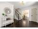 Bright foyer with dark wood floors, decorative mirror, and view of the dining room at 320 Woodlake Ct, Alpharetta, GA 30005