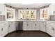 Bright kitchen with stainless steel appliances, white cabinets, and corner window sink at 320 Woodlake Ct, Alpharetta, GA 30005