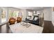 Open-concept living room featuring multiple seating options, a fireplace, and an area rug at 320 Woodlake Ct, Alpharetta, GA 30005