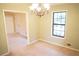 Cozy dining area with simple chandelier, neutral walls, and view of the living room at 326 Rockland Way, Lawrenceville, GA 30046
