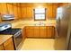 Functional kitchen with stainless steel appliances, wooden cabinets, and tiled floors at 326 Rockland Way, Lawrenceville, GA 30046