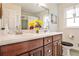 Bright bathroom with a dual sink vanity, wooden cabinets, modern fixtures, and a large mirror at 800 Glenairy Dr, Atlanta, GA 30328