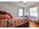 Bedroom with hardwood floors, bed with colorful covers and pillows, and bright windows with sheer curtains at 800 Glenairy Dr, Atlanta, GA 30328