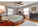 Spacious bedroom with a wooden bed frame, ceiling fan, hardwood floors, and bright windows at 800 Glenairy Dr, Atlanta, GA 30328