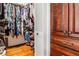 Walk-in closet with custom shelving, ample storage, wood flooring, and adjacent custom wood cabinet at 800 Glenairy Dr, Atlanta, GA 30328