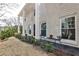 Close up of the exterior of the white brick home featuring pillars and outdoor seating, inviting relaxation at 800 Glenairy Dr, Atlanta, GA 30328