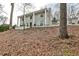 View of the white brick home showing the front yard and trees, creating a serene and inviting atmosphere at 800 Glenairy Dr, Atlanta, GA 30328