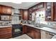 This kitchen features stainless steel appliances, dark wood cabinetry, and marble countertops at 800 Glenairy Dr, Atlanta, GA 30328