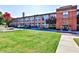 Brick building exterior featuring large windows, landscaping, and parking area at 1261 Caroline St # 211, Atlanta, GA 30307