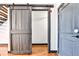 Hallway featuring hardwood floors, gray walls and a barn-style door at 1261 Caroline St # 211, Atlanta, GA 30307