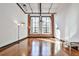 Spacious living room with hardwood floors, exposed brick, and lots of natural light from large windows at 1261 Caroline St # 211, Atlanta, GA 30307