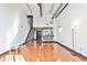 Bright living room with hardwood floors, high ceilings, staircase, and modern fixtures at 1261 Caroline St # 211, Atlanta, GA 30307
