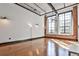 Spacious living room featuring hardwood floors, large windows and exposed brick at 1261 Caroline St # 211, Atlanta, GA 30307
