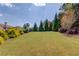 A large backyard with lush grass, mature trees, and a picturesque landscape at 1433 Henderson Ridge Ln, Loganville, GA 30052