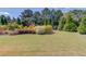 Expansive backyard with lush greenery, mature trees, and a trampoline at 1433 Henderson Ridge Ln, Loganville, GA 30052