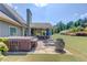 Backyard features a hot tub, covered patio, stone patio, lounging chairs and manicured landscaping at 1433 Henderson Ridge Ln, Loganville, GA 30052