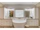 Bright bathroom with white cabinets, freestanding tub, double sinks, and modern fixtures at 1433 Henderson Ridge Ln, Loganville, GA 30052