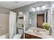 Bathroom with shower-tub combo, toilet, white storage shelf and vanity with decorative mirror above at 1433 Henderson Ridge Ln, Loganville, GA 30052