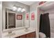 Bathroom featuring double sinks, decorative mirrors, tile floor and a combination tub-shower at 1433 Henderson Ridge Ln, Loganville, GA 30052