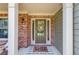 Inviting front door with brick accents, a 'hello' welcome mat, and charming wreath at 1433 Henderson Ridge Ln, Loganville, GA 30052