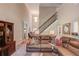 Bright and airy living room featuring a staircase, large windows, and comfortable seating at 1433 Henderson Ridge Ln, Loganville, GA 30052