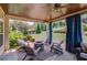 Outdoor patio featuring comfortable seating, fire pit, ceiling fan, stone floor and landscaped backyard at 1433 Henderson Ridge Ln, Loganville, GA 30052