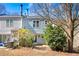 Backyard patio view showcasing mature trees, plantings and a rear view of the light blue home at 2003 Queen Anne Ct, Sandy Springs, GA 30350
