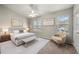 Bright main bedroom featuring a ceiling fan, neutral paint, and a comfortable sitting area near the windows at 2003 Queen Anne Ct, Sandy Springs, GA 30350