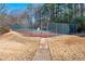 Fenced tennis court with a view of surrounding trees at 2003 Queen Anne Ct, Sandy Springs, GA 30350