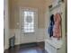 Inviting entryway with a white hall tree and bench for storage, complemented by wainscoting and dark hardwood floors at 117 Jacobs Ln, Loganville, GA 30052