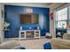 Stylish living room featuring a blue accent wall, large TV, electric fireplace, and cozy seating for entertainment at 117 Jacobs Ln, Loganville, GA 30052