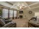 Spacious living room with a coffered ceiling, fireplace, large windows, and comfortable reclining seating for relaxation at 117 Jacobs Ln, Loganville, GA 30052