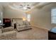 Spacious main bedroom with tray ceiling, ceiling fan, and sitting area for relaxation at 117 Jacobs Ln, Loganville, GA 30052