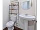 Well-lit powder room with a pedestal sink and stylish storage shelving at 1468 Harlequin Way, Stockbridge, GA 30281