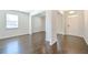 Open living space with dark hardwood flooring, light colored walls, and large windows at 1468 Harlequin Way, Stockbridge, GA 30281