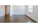 Bright living room features hardwood flooring, neutral walls, and natural light from the window at 1468 Harlequin Way, Stockbridge, GA 30281