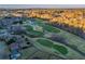 An aerial view showcases the lush golf course with mature trees and beautiful surrounding landscape at 403 Tea Olive Ct, Canton, GA 30115
