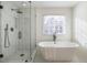 Bathroom featuring glass-enclosed shower and soaking tub at 403 Tea Olive Ct, Canton, GA 30115