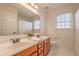 Bathroom features double sinks, a vanity with wood cabinets, and a framed mirror over a tile floor at 403 Tea Olive Ct, Canton, GA 30115