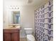 Standard bathroom featuring a sink, toilet, framed mirror and a shower with a patterned curtain at 403 Tea Olive Ct, Canton, GA 30115